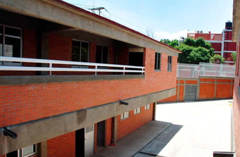 Edificio de ladrillo rojo con dos pisos y un balcón