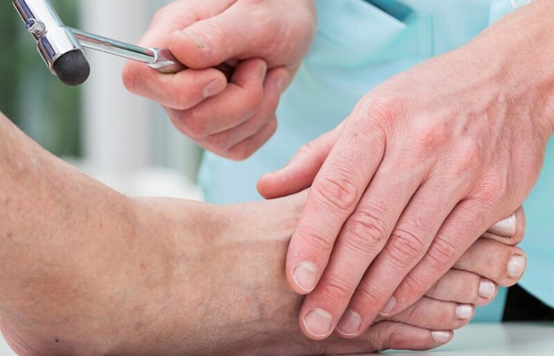 Médico examinando el pie de un paciente