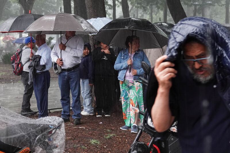 Personas que realizaban diversas actividades la tarde en la Alameda Central buscaron resguardarse ante las fuertes lluvias registradas en la capital.