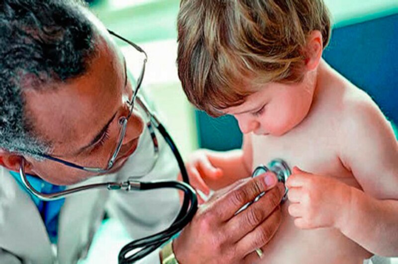 Un médico ausculta el pecho de un niño con un estetoscopio.