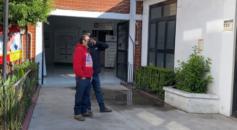 Dos hombres platican frente a un negocio local
