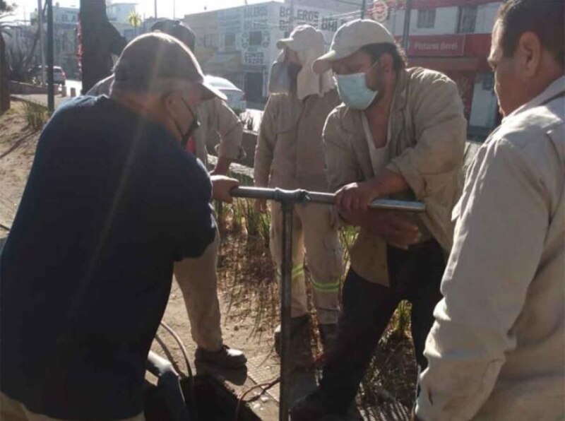 Trabajadores de la CFE reparando un tubo en la calle