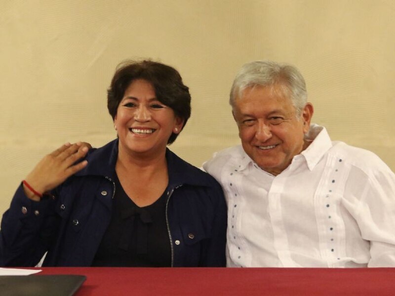 AMLO y Sheinbaum sonríen durante una conferencia de prensa