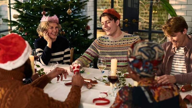 Familia jugando un juego de mesa en la cena de Navidad