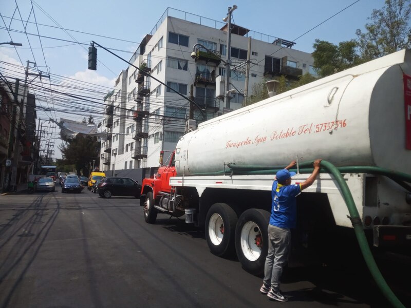 Un camión de agua potable abastece a un edificio en la Ciudad de México