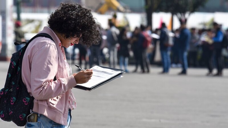 Jovencita rellenando un formulario en la calle
