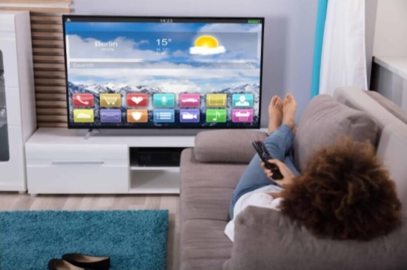 Mujer viendo la televisión en el sofá