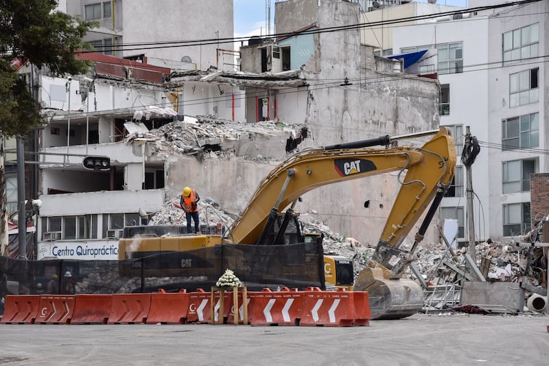 Los trabajos de remoción de escombros del edificio derrumbado en Álvaro Obregón 286. En la imagen un operador de maquinaria pesada barre el polvo de la unidad.