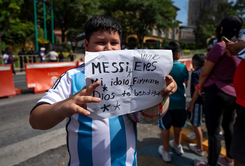 Niño sostiene un cartel que dice "Messi eres mi ídolo, Dios te bendiga"