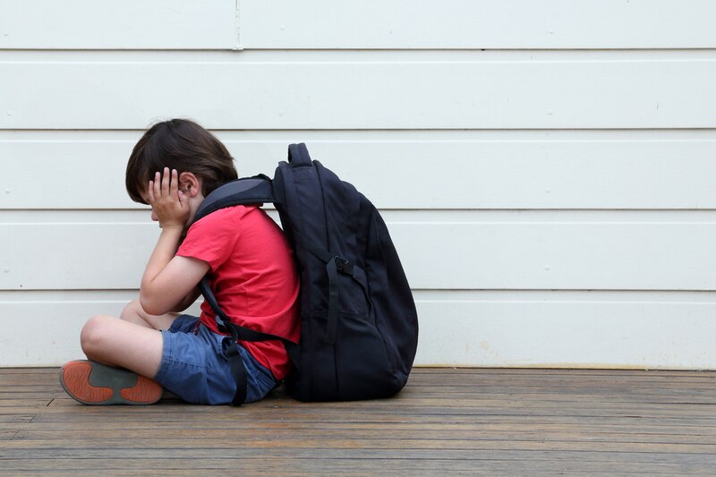 Niño triste sentado en el suelo