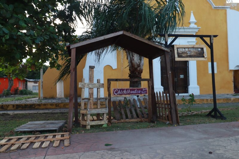 Imagen de una casa de madera con un cartel que dice "Villa de Medellín 1812".