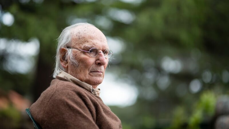 Un anciano sentado en una silla en el jardín