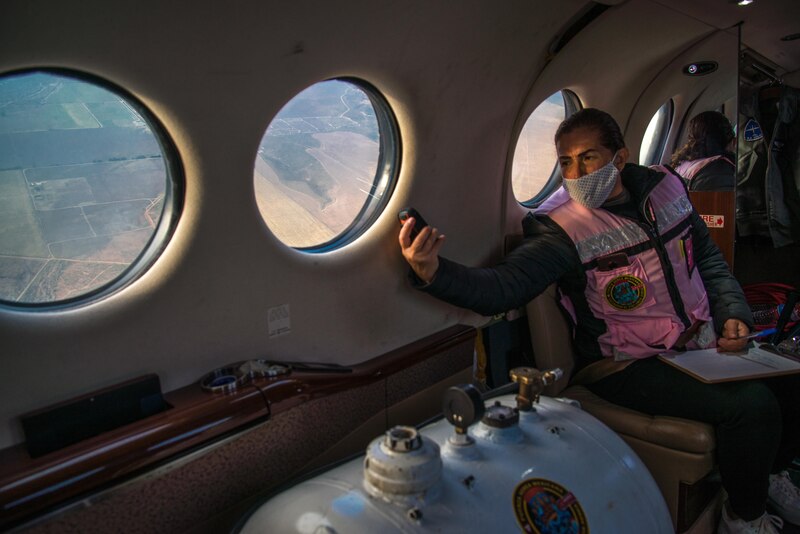 Mujer tomando una foto desde la ventana de un avión