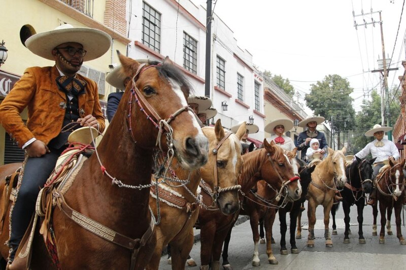 Jinetes a caballo en traje tradicional mexicano