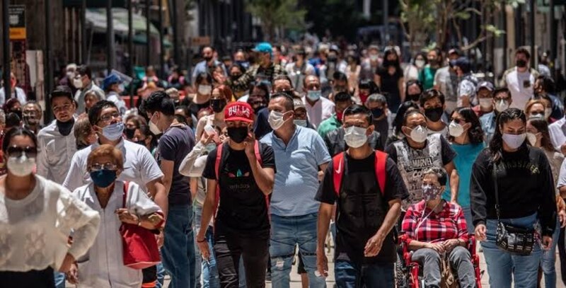 Multitud de personas con mascarillas caminando por una calle de la ciudad