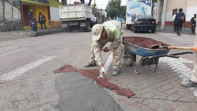 Trabajador repara bache en la calle