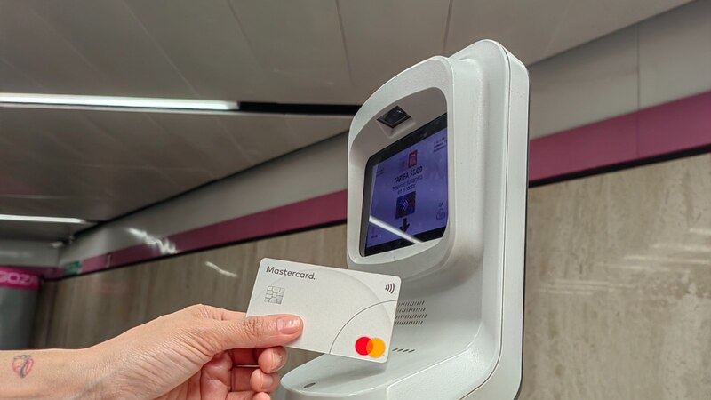 Mujer usando tarjeta Mastercard para pagar el metro