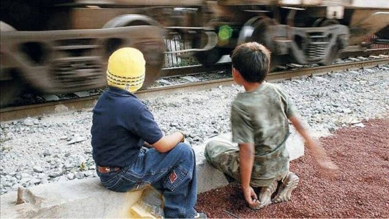Niños jugando cerca de las vías del tren