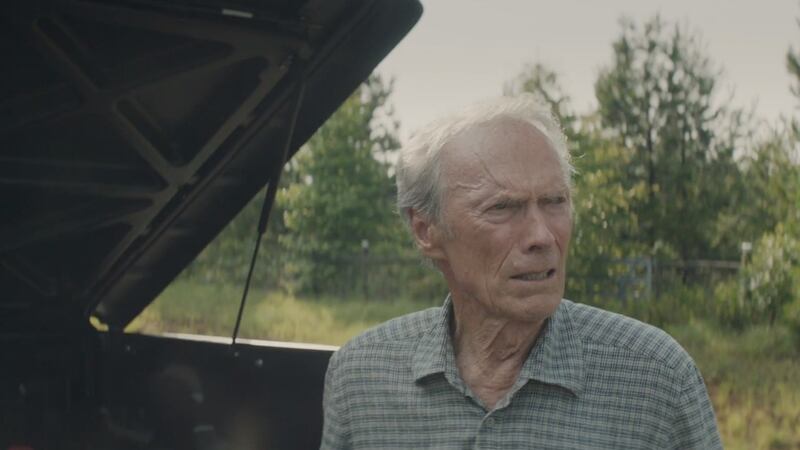 Clint Eastwood mirando el motor de un coche