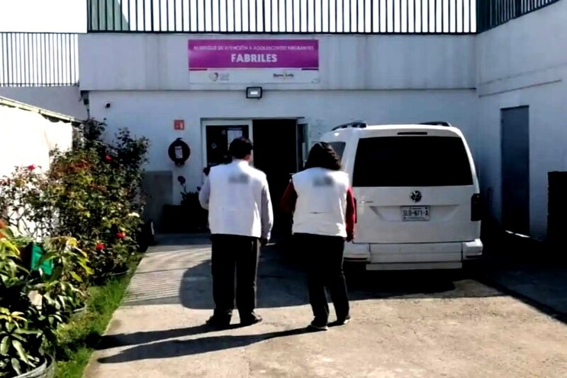 Dos personas de pie frente a una camioneta blanca