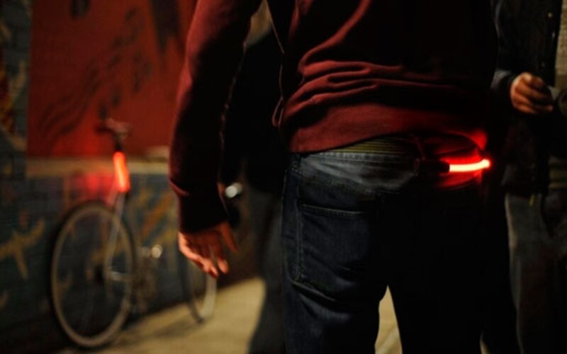 Ciclista urbano con luz de seguridad en la cintura