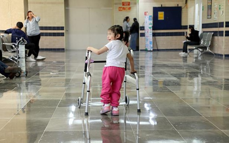 Ailyn, una niña de cuatro años, camina con su andadera tras vencer el cáncer en la médula espinal