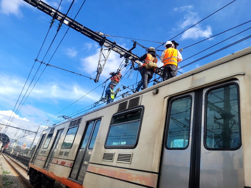 Trabajadores de mantenimiento en el techo de un tren