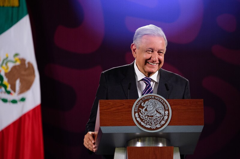 El presidente Andrés Manuel López Obrador sonríe durante un discurso.