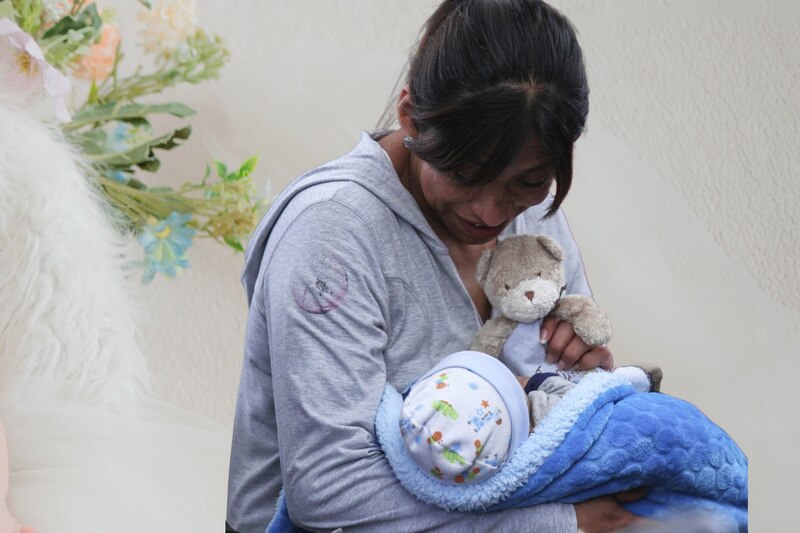 Una mujer cargando a su bebé