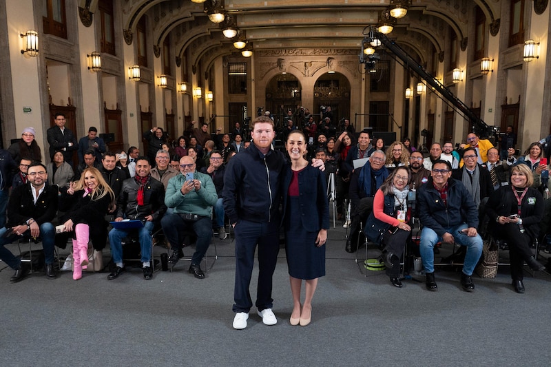 Fotografía cedida por la presidencia de México, de la presidenta de México, Claudia Sheinbaum (d), junto al boxeador mexicano Saúl 'Canelo' Álvarez, posando frente a periodistas al termino de una rueda de prensa este viernes, en Palacio Nacional de la Ciudad de México (México). ‘Canelo’ Álverez acompañó a Sheinbaum durante su conferencia matutina, en donde le entregó un cinturón del Consejo Mundial de Boxeo (CMB) y unos guantes blancos en símbolo de paz e inspiración a los jóvenes a practicar deporte.