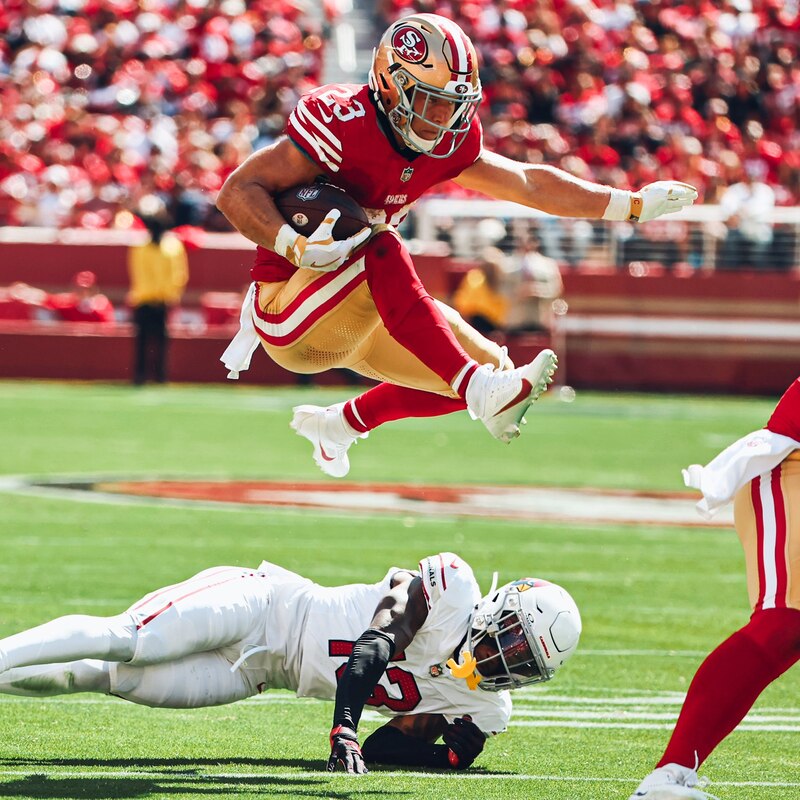 El jugador de fútbol americano George Kittle salta sobre un jugador del equipo contrario para anotar un touchdown.