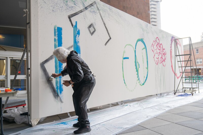 Artista pinta un mural en una pared