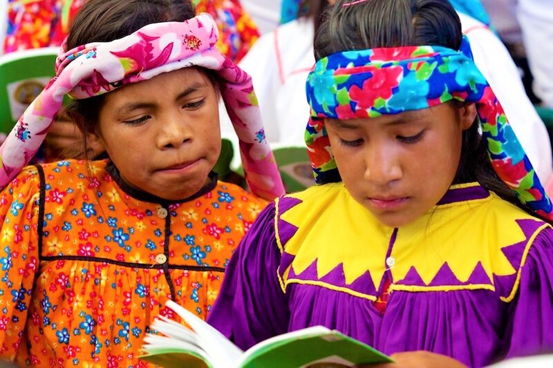 Niñas indígenas leyendo un libro