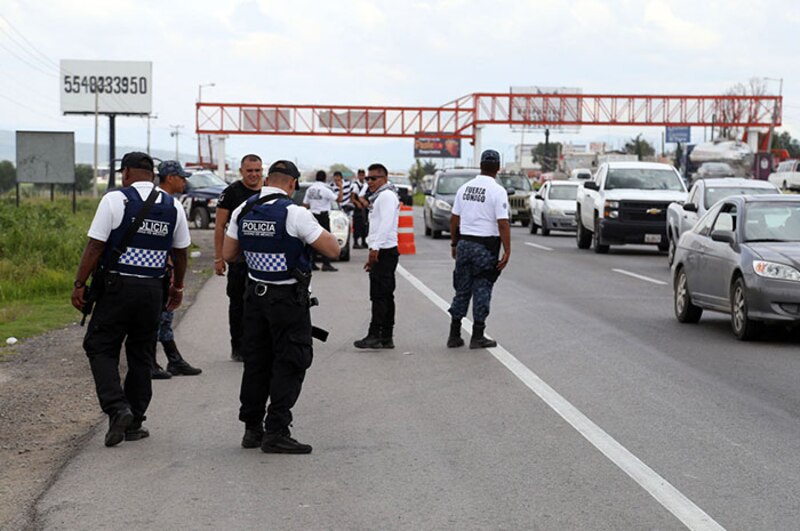 Policías mexicanos detienen vehículos en una carretera
