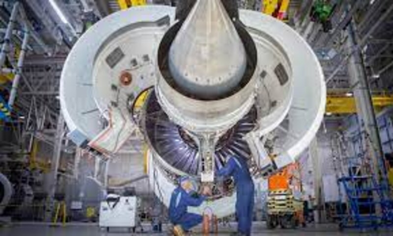 Dos mecánicos trabajan en el mantenimiento de un motor de avión.
