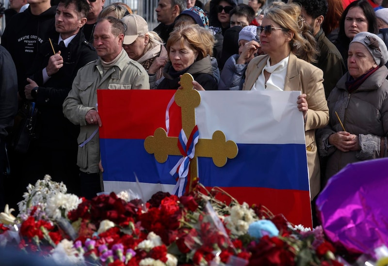 Mujeres ucranianas con una bandera en un funeral