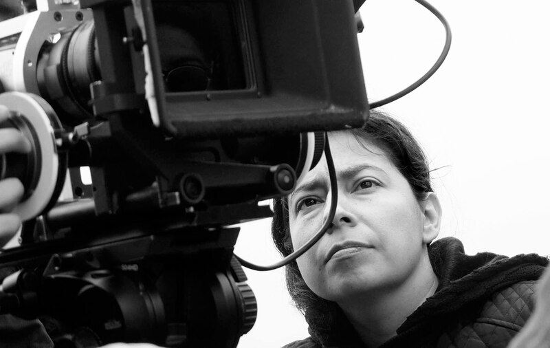 Mujer cineasta mirando por la cámara