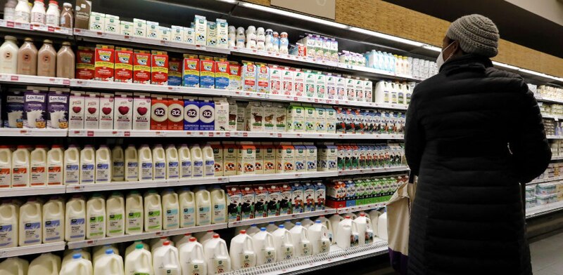 Mujer mirando productos lácteos en el supermercado