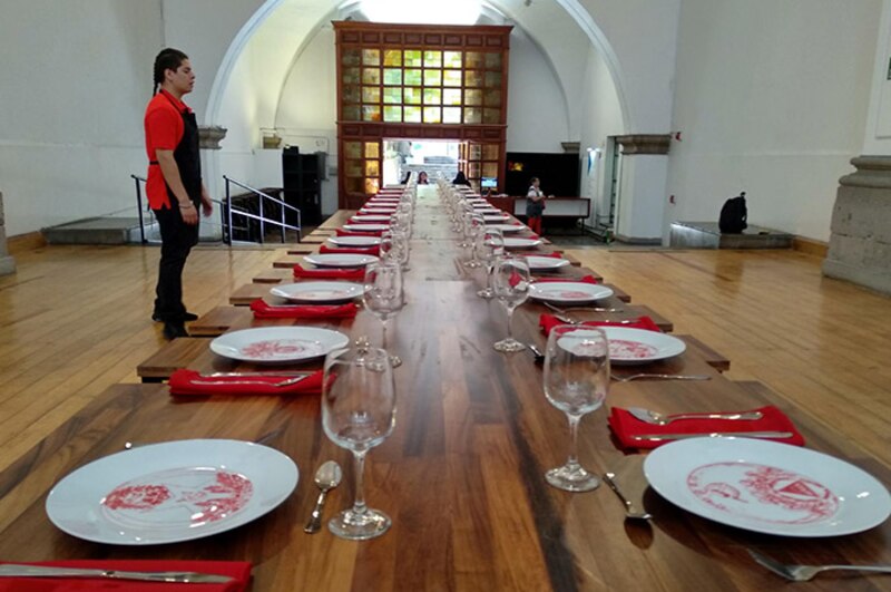 Una mesa larga con manteles y sillas en un salón