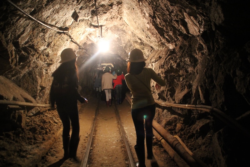 Un grupo de personas camina por un túnel oscuro en una mina.