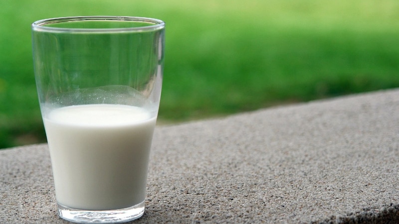 Un vaso de leche sobre una mesa