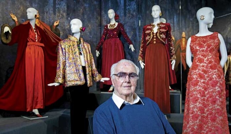 El diseñador de moda Yves Saint Laurent junto a sus creaciones.
