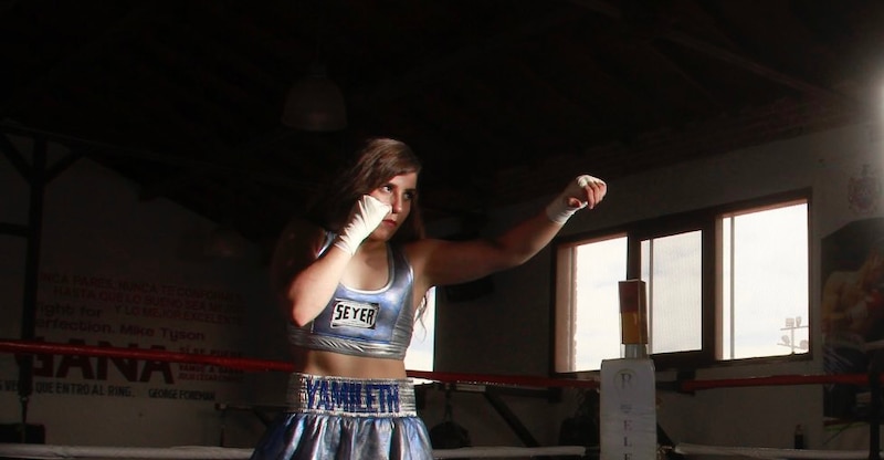 Joven boxeadora entrenando en el ring