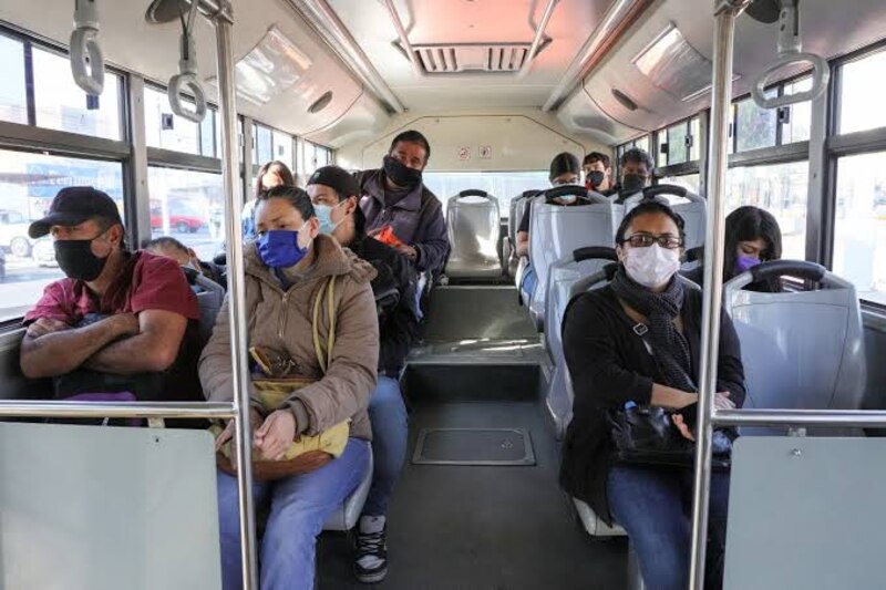 Pasajeros en un autobús llevan mascarillas durante la pandemia de COVID-19