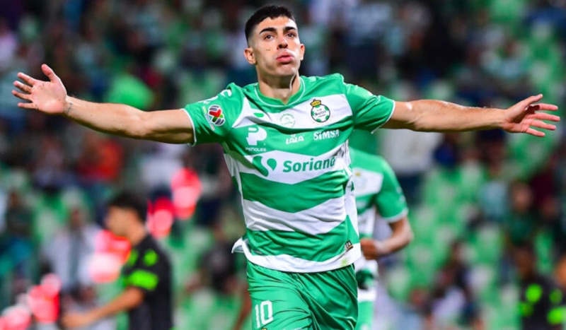 El jugador de fútbol celebra su gol con los brazos abiertos
