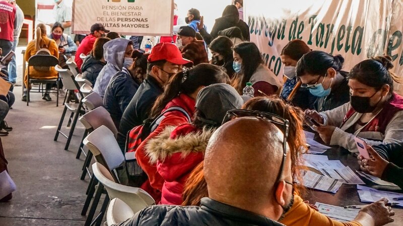 Personas esperando en fila para recibir la pensión para adultos mayores