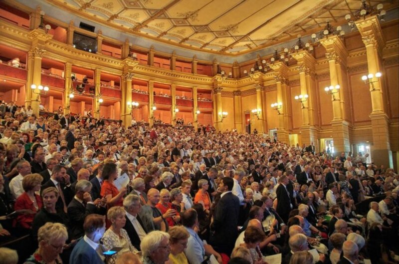 Un público numeroso asiste a un concierto en un teatro.