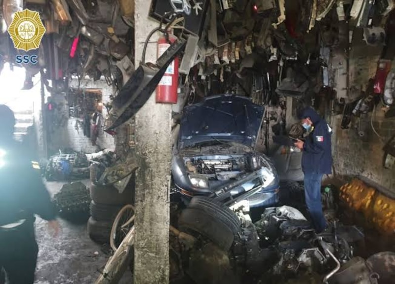 Un mecánico trabaja en un coche en un taller mecánico