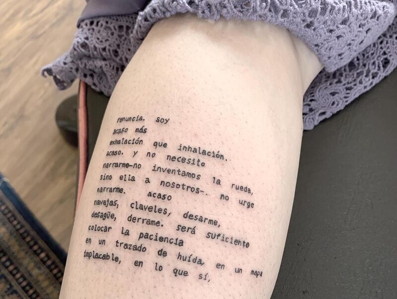 Poema tatuado en la pierna de una mujer