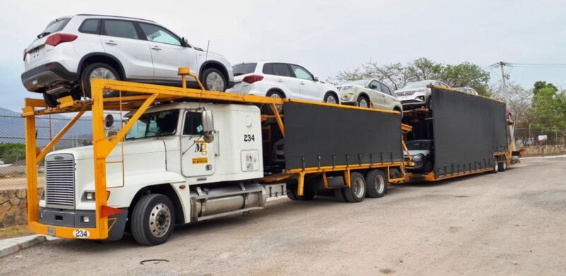 Camión de plataforma con coches nuevos